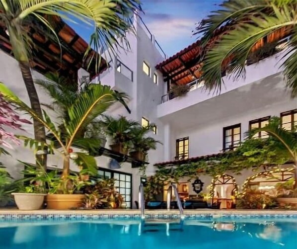 Swimmers can enjoy the pool surrounded by lush greenery.