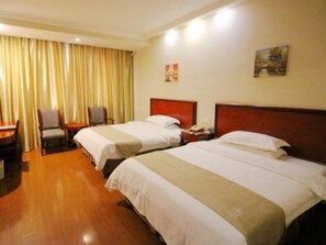 Une chambre d’hôtel avec deux lits, un bureau, une chaise et un tableau au mur.