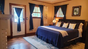 A bedroom with a large bed, a nightstand with a lamp, and a framed picture on the wall. - Idyllic Cottage Memory Making with Pool & Outdoor Fireplace under the Gazebo, (Spokane Valley)