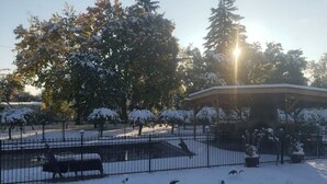 A gazebo in a park with snow-covered trees and a bench. - Idyllic Cottage Memory Making with Pool & Outdoor Fireplace under the Gazebo, (Spokane Valley)
