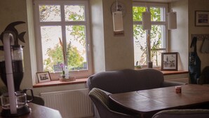 Ein gemütlicher Essbereich mit kariertem Boden, einem Holztisch und zwei grau gepolsterten Stühlen.