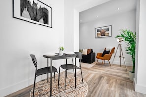 Un espace repas moderne avec une table ronde, des chaises et un tapis.