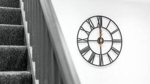 Eine Treppe mit einer modernen Uhr an der Wand.