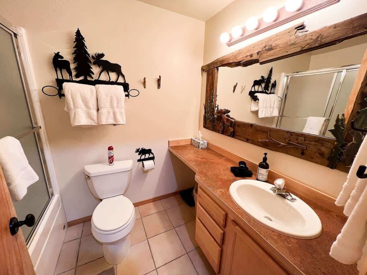 Une salle de bain avec des toilettes, un lavabo et un miroir.