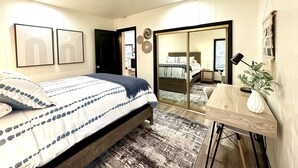 Ein Schlafzimmer mit Bett, Nachttisch und Spiegel.