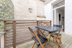 Relax in an outdoor seating area with a table and two chairs on a spacious deck.