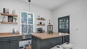 A modern kitchen with a central island, bar stools, and built-in appliances.