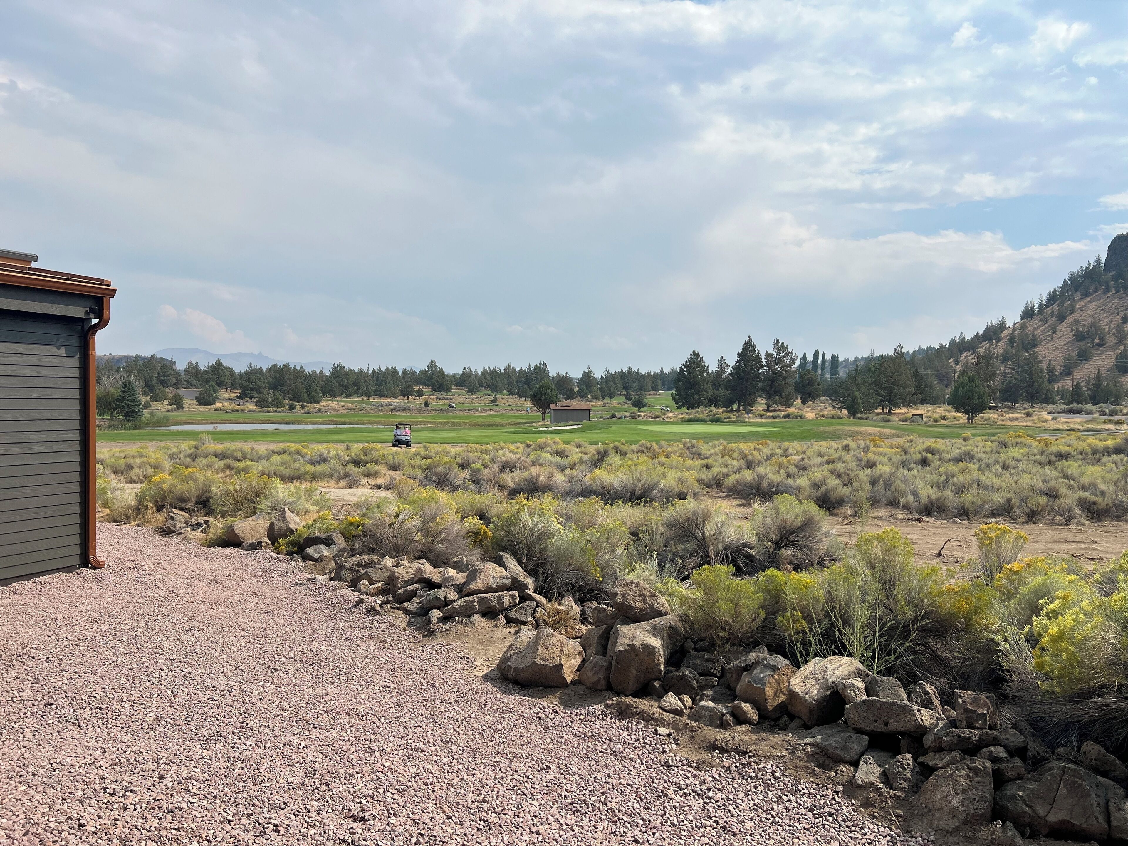 Une vue sur un terrain de golf, avec un bâtiment au premier plan.