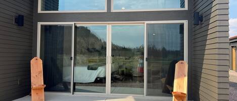 A modern building with a large glass door and two wooden posts.