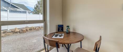 A corner room with a round table, two chairs, a window, and a 'Welcome to the Carlin's' sign.
