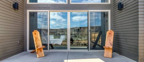 A modern building with a large glass door and two wooden boards leaning against it.