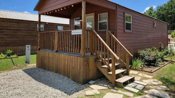 Eine Holzhütte mit Veranda, Treppe und einem Schild, auf dem 'Rosewood' steht.