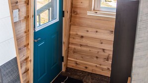 A wooden interior with a teal door, a window, and a black doormat. - Legacy Lighthouse, Amish Country Ohio, Sugarcreek (Sugarcreek)