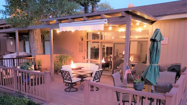 A covered outdoor patio with a table and chairs, a small American flag, and a grill. - Flagstaff Golf Course Condo - 9th Green of Continental Country Club (Flagstaff)