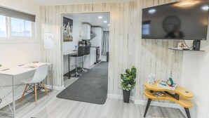 Un espace de bureau moderne comprenant un bureau, une chaise et un téléviseur fixé au mur.