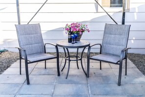 Two chairs and a table with a flower arrangement and two glasses on the table. - Adorable cottage with king Size bed and a short distance to WW University (Walla Walla)