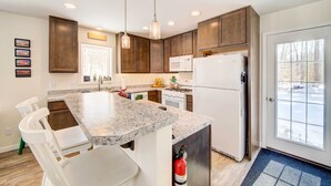 A modern kitchen with granite countertops, stainless steel appliances, and wooden cabinets. - Maine Cottage w/ Dock & Kayaks, Near Augusta! (Augusta)