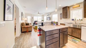 A modern kitchen with a central island, dark cabinetry, and pendant lighting. - Maine Cottage w/ Dock & Kayaks, Near Augusta! (Augusta)