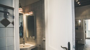 Une salle de bain avec un lavabo, un miroir et des murs carrelés.
