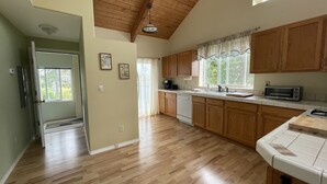 A spacious kitchen with wooden cabinets, a dishwasher, and a microwave. - Bayshore RV Park & Guest Suites (Tokeland)
