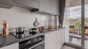 Cocina moderna con estufa integrada, un ventanal grande y vistas al exterior.