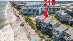 Un hôtel situé sur la côte, composé de plusieurs bâtiments, avec une plage et une piscine.
