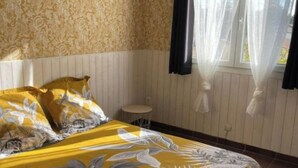 Ein Schlafzimmer mit einem großen Bett, einem kleinen runden Tisch und einem Deckenventilator.