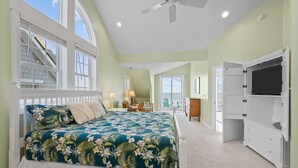 A bedroom with a large bed, a TV, and a view of the ocean. - 5BR Oceanfront Home on North Topsail Sleeps 15 - Pool & Hot Tub (North Topsail Beach)