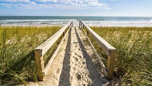 A wooden boardwalk leading to a beach with sand and grass on either side. - 4BR Oceanfront House - Sleeps 15 on North Topsail Beach - Pool (North Topsail Beach)