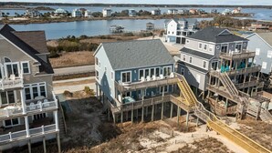 A coastal residential area with multiple houses, some with balconies and decks, near a body of water.