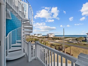Een modern gebouw met een spiltrap en uitzicht op het strand en de oceaan.