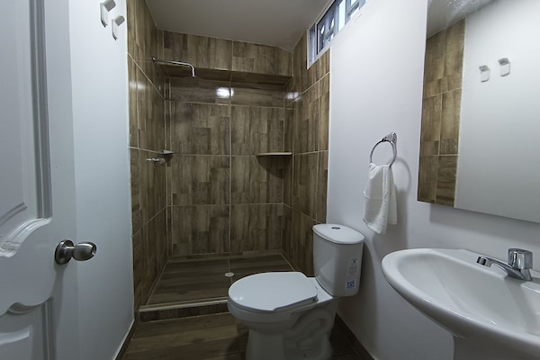 Quarto casal standard | Banheiro | Chuveiro, toalhas de banho, sabonete, papel higiênico