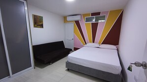 A bedroom with a bed, a sofa, a door, and an air conditioning unit on the wall. - Ayenda Brisas del Rio (Barranquilla)