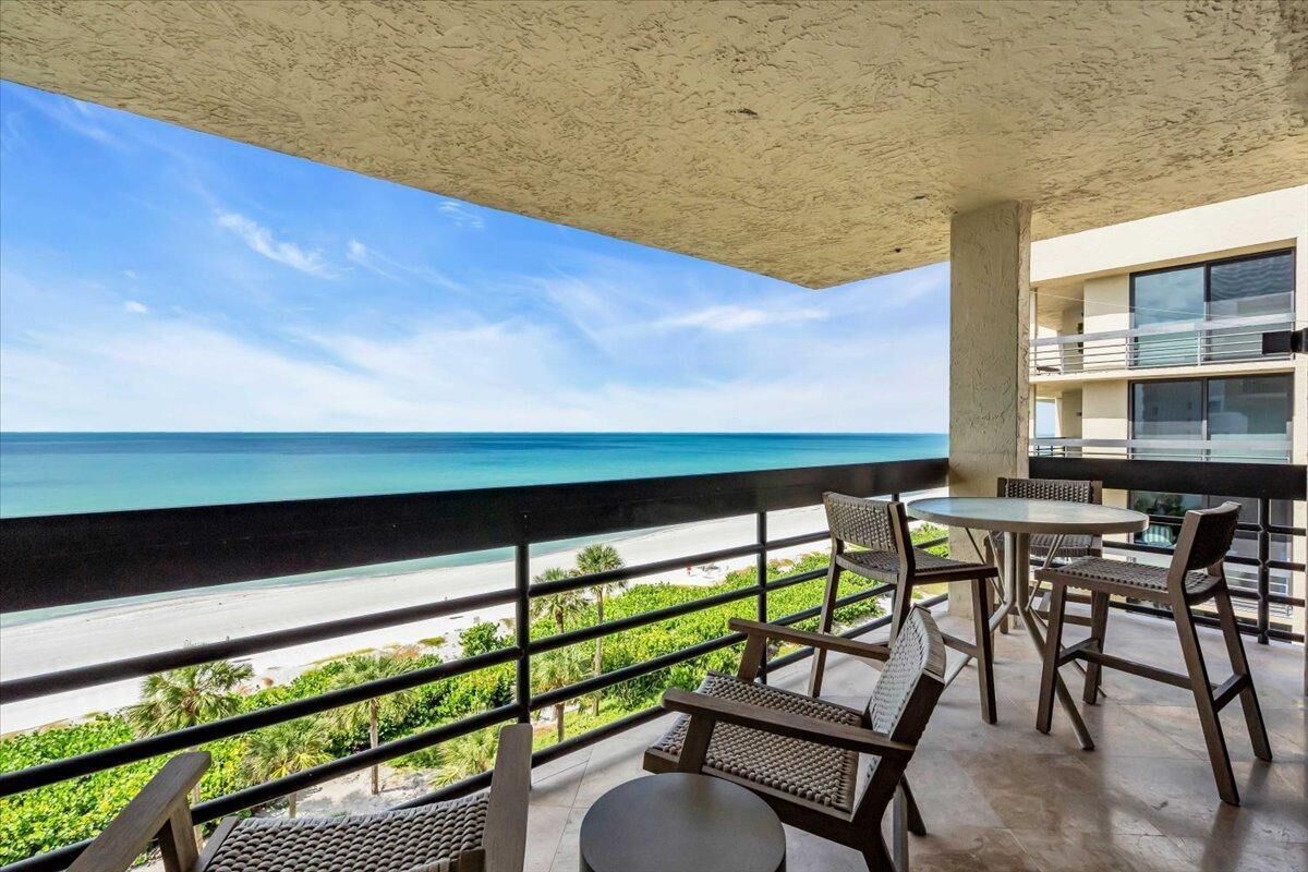 A balcony with a view of the beach and ocean.