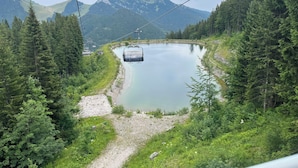Un sistema de teleférico sobre un lago, con montañas al fondo.
