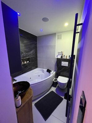 Une salle de bain moderne avec une baignoire sur pieds, des toilettes et un meuble-lavabo avec un évier.