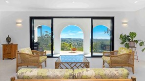 Relax in a serene space with a stunning view, a central table, and plush sofas.