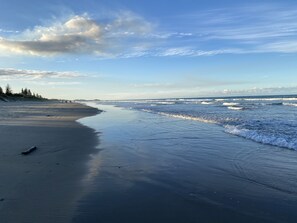 Enjoy a serene beach experience with gentle waves lapping onto the shore.