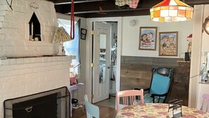 Una habitación acogedora con chimenea, una mesa de comedor con sillas y una lámpara colgante.