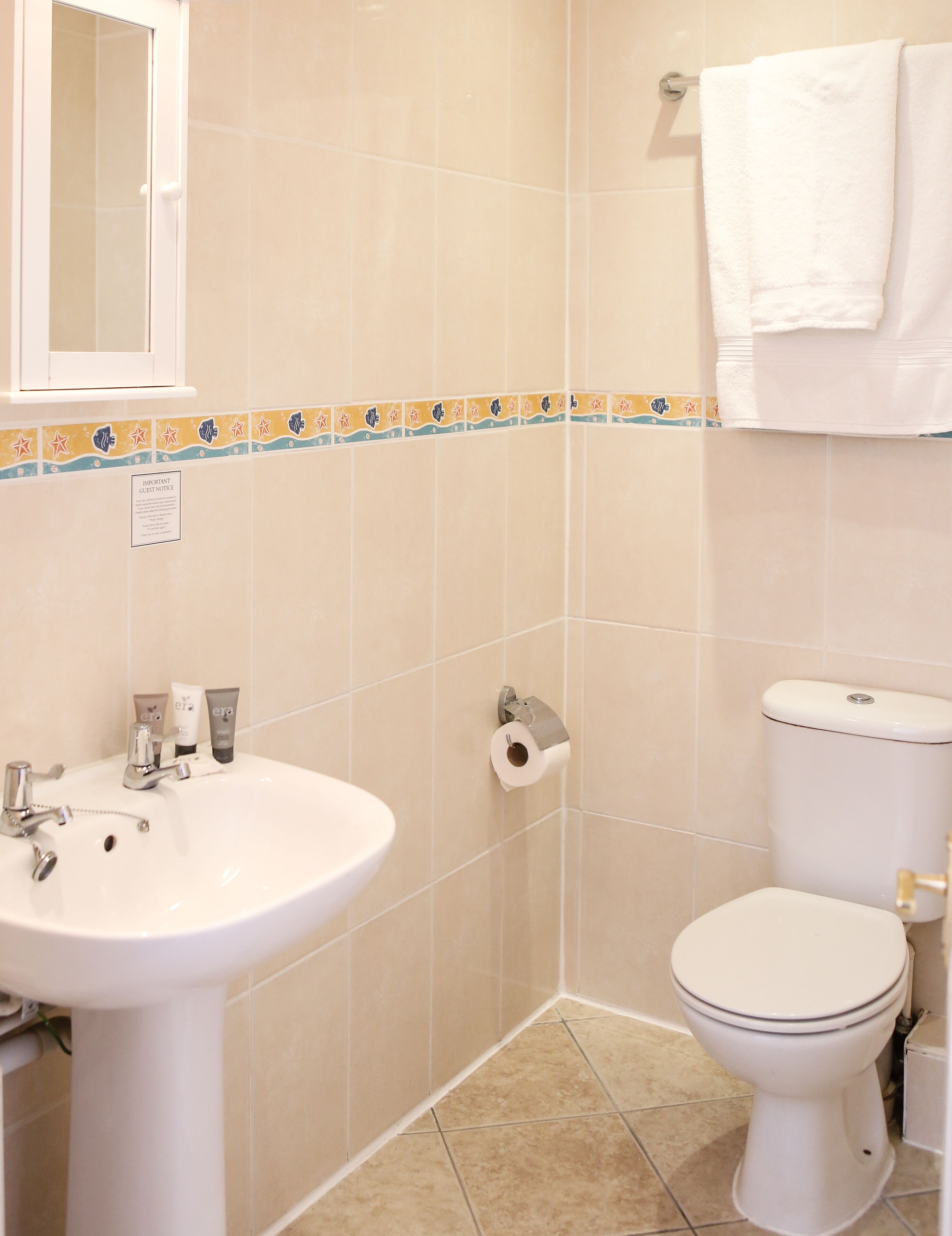 A bathroom with a sink, toilet, and a towel rack.