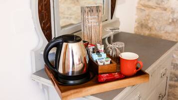 A kitchen counter with a coffee maker, a wooden sign, a red mug, and various food items.