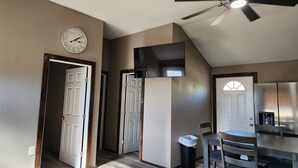 Une cuisine moderne avec un coin repas, un ventilateur de plafond et une horloge au mur.