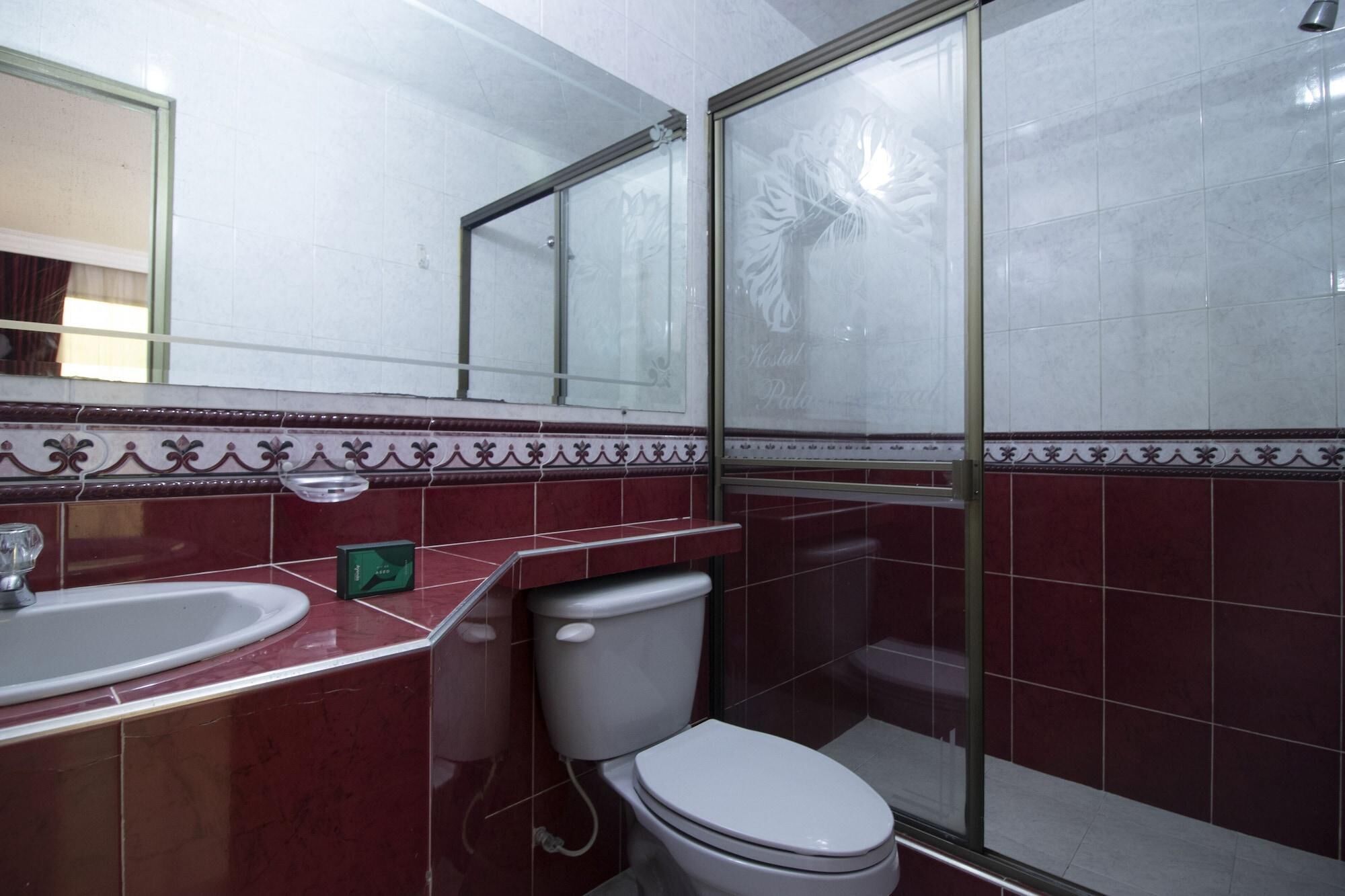 A bathroom with a sink, toilet, and glass shower enclosure.