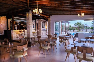 A restaurant with outdoor seating, a bar area, and a view of a pool.