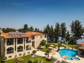 A building with a swimming pool, solar panels, and a well-maintained garden.