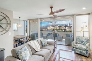 A modern living room with a sofa, armchair, and dining table.