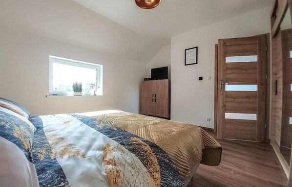 Un dormitorio con cama, ventana, armario y puerta.