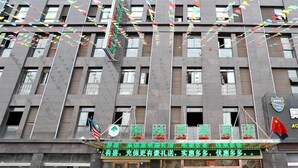 A hotel with a modern facade, multiple windows, and a green signboard with Chinese characters. - Greentree Inn Yancheng Jianhu East Huiwen Road Columbus Square Business Hotel (Yancheng)