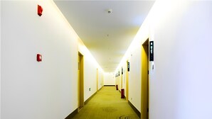 A long, narrow hotel corridor with a carpeted floor and white walls. - Greentree Inn Huanggang City Wuxue City Kanjiang Avenue (Huanggang)