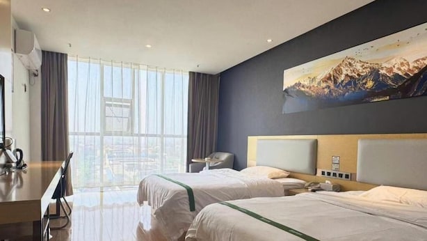 A hotel room with two beds, a desk, and a large window with a view of the city. - Greentree Inn Huanggang City Wuxue City Kanjiang Avenue (Huanggang)